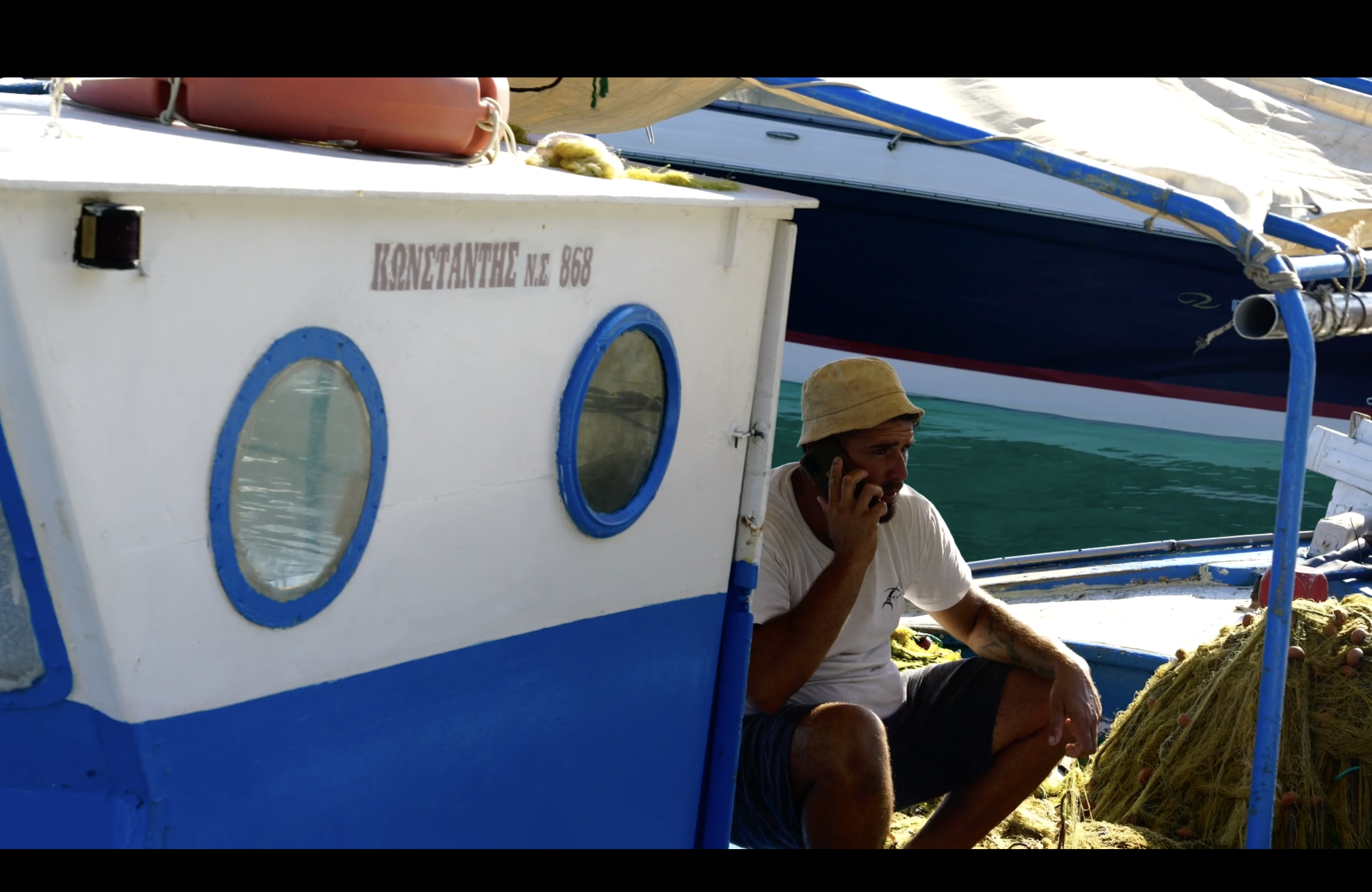 Greek American filmmaker Alexander Pagonis filming on a fishing boat in Samos for his documentary Man Over Aegean